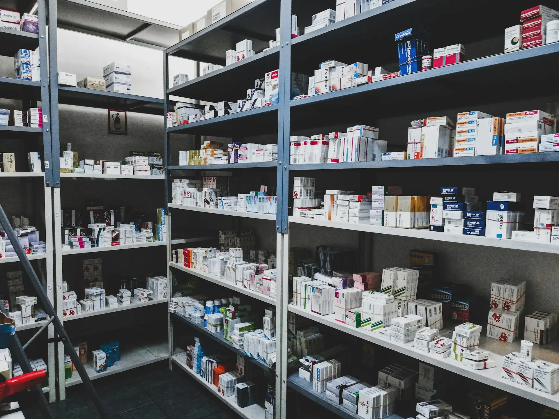 Anaquel de farmacia con medicamentos ordenados en estantes